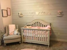 a baby's room with a crib, chair and wall name on the wall