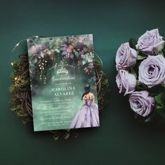 a book and flowers on a green surface next to each other with the cover open