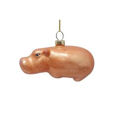 an ornament shaped like a hippopotamus hanging from a cord on a white background