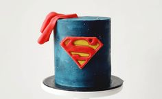 a blue cake with a superman symbol on it