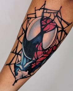 a spider - man tattoo on the arm with webs around it and a red orb in the center