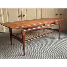 a wooden coffee table sitting on top of a carpeted floor