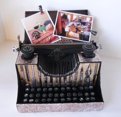 an old fashioned typewriter with pictures on it's side and other items sitting on top