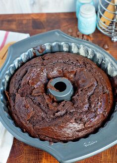 a chocolate bundt cake in a pan on a wooden table