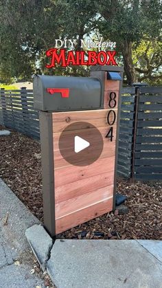 a mailbox sitting on the side of a road next to a fence and trees