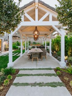 an outdoor dining area is shown in the evening hours with lights hanging from the roof