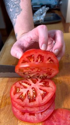 a person is slicing tomatoes on a cutting board