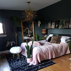 a bedroom decorated in shades of pink and green with cactus decorations on the wall, rugs and bedding