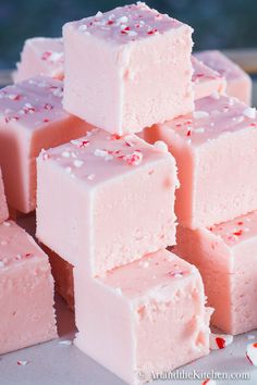 several pieces of pink fudge are stacked on top of each other with the words candy cane written above them