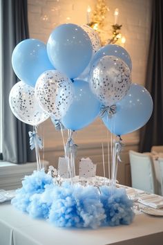 a table topped with blue and white balloons