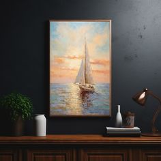 a painting hanging on the wall above a desk with a lamp and vases next to it