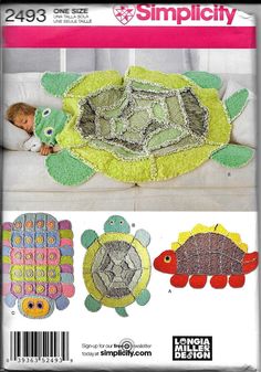 a child laying on top of a couch next to two turtle rugs and a pillow