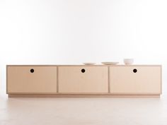 the sideboard has three bowls on it and is made out of plywood wood