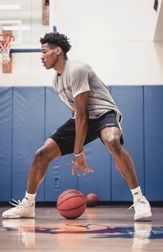 a basketball player dribbles the ball on an indoor court