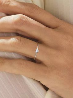 a woman's hand with a diamond ring on it