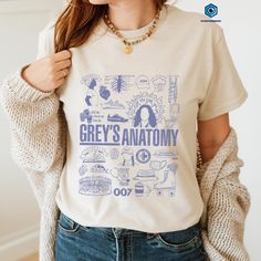 a woman wearing a grey's anatomy t - shirt with blue writing on it