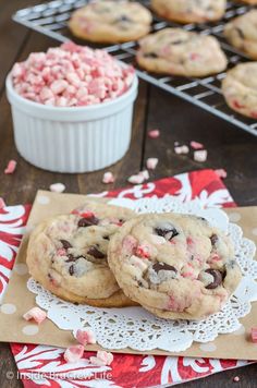 two chocolate chip cookies with pink and white sprinkles on a doily