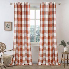 an orange and white checkered curtain hangs in front of a window with a chair next to it