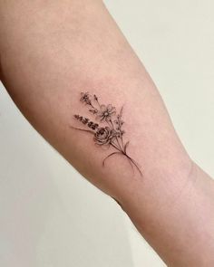 a small flower tattoo on the arm