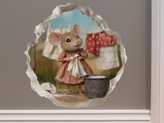 a glass ornament with a painting of a mouse holding a bucket and clothes