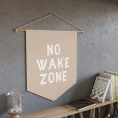 a sign that says no wake zone hangs on the wall next to a shelf with books