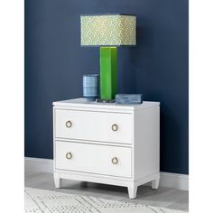 a green lamp sitting on top of a white dresser