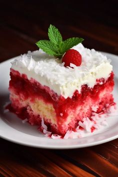 a piece of red velvet cake with white frosting and raspberries on top