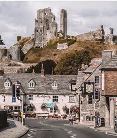 an old town with stone buildings on the top of it and a castle in the background