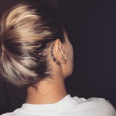 a woman with a tattoo behind her ear