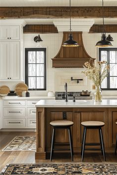 a kitchen with two stools in front of an island