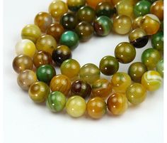 multicolored glass beads are lined up on a white surface, with one bead in the middle