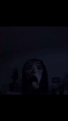 a woman with her mouth open in the dark