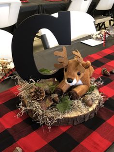 a table with a red and black checkered table cloth topped with a deer head