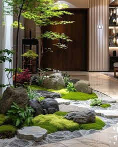 an indoor garden with rocks and plants in the center, surrounded by white stones and green grass