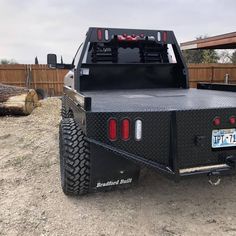 the back end of a truck parked on dirt