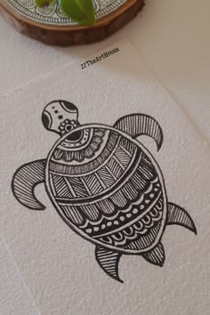 a drawing of a turtle on paper next to a potted plant