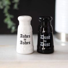 two black and white salt and pepper shakers sitting on a counter next to each other