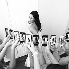 a group of people holding up cell phones in front of a woman's face