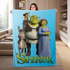 a woman is holding up a blanket with the characters from shrak on it