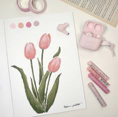 some pink flowers are sitting on a table next to markers, tape and other crafting supplies