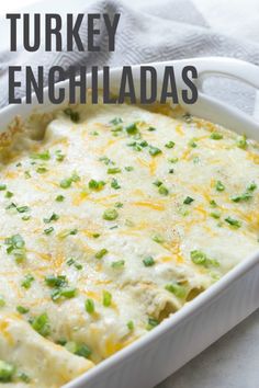 a white casserole dish filled with turkey enchiladas