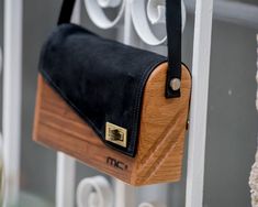 a wooden purse hanging from the side of a window