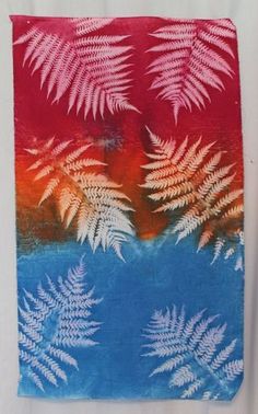 a red, white and blue painting with some leaves on it's back side