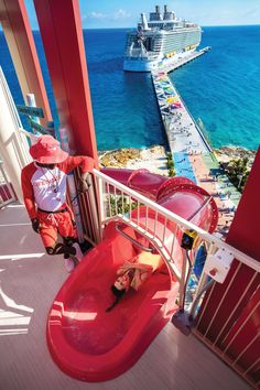 a woman is sitting in a red tub on the deck of a cruise ship