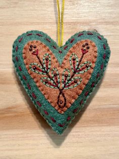 This sweet heart ornament was made from a wool blend felt and has been embroidered with love. The design is from Larissa Holland from mmmcrafts and is part of the Twelve Days ornament series. This would make the perfect gift topper as well as a Christmas, Valentine or everyday ornament. If you would like custom colors, or multiple ornaments, send me a message! Pattern by Larissa Holland, Mmmcrafts.blogspot.com Felt Embroidery Ornaments, Felt Art Embroidery, Felt Heart Ornaments, Merry Chrysler, Hand Stitching Techniques, Felt Mushroom, Felt Creations, Felt Crafts Diy, Felt Embroidery