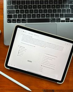 a laptop computer sitting on top of a wooden desk next to a cup of coffee