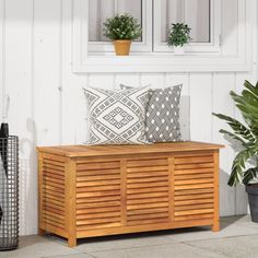 a wooden bench sitting next to a potted plant on top of a tiled floor