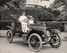 an old fashion car with two women sitting in it