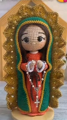 a crocheted doll with a red dress and green shawl