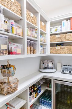 an organized pantry with lots of food and drinks in baskets on the shelves, along with other items